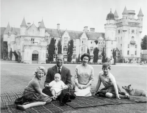 Getty Images Baby Prince Andrew perches on Prince Philip's lap during a picnic in the grounds of Balmoral Castle. Also pictured are Queen Elizabeth, Prince Charles, and Princess Anne.