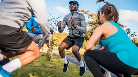 Getty Images Group of people exercising in park