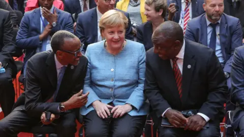 AFP President of the Republic of Rwanda, Paul Kagame, German Chancellor Angela Merkel and President of the Republic of South Africa Matamela Cyril Ramaphosa attend the G20 Investment Summit