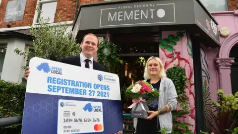 Economy Minister Gordon Lyons with Milana Surova of Memento florists on the Ormeau Road, Belfast