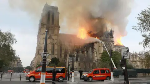 Getty Images Flames and smoke are seen billowing from the roof at Notre-Dame Cathedral April 15, 2019 in Paris, France.