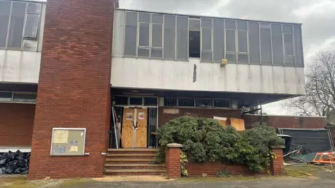 Harea Homes Rushden Police Station looking run down with derelict paint and debris surrounding the building. 