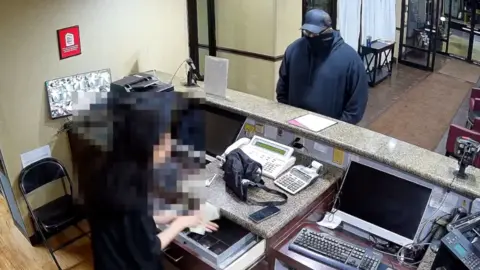 An unidentified man is robbing a Red Roof Inn hotel.