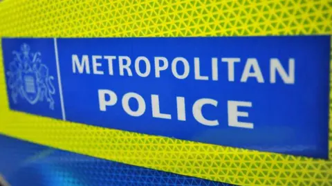 A yellow and blue sign containing the white words "METROPOLITAN POLICE" 