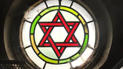 The National Lottery Heritage Fund A close up of one of the synagogue's stained circular glassed windows showing the Star of David.