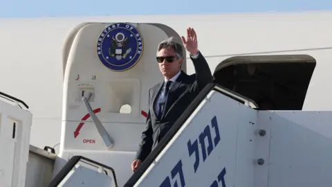 رویترز، آنتونی بلینکن، وزیر امور خارجه ایالات متحده، هنگام ورود به فرودگاه بن گوریون تل آویو در اسرائیل (10 ژوئن 2024) دست تکان می دهد.