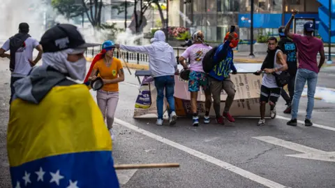 EPA riot police fired tear gas and rubber bullets at protesters in Caracas as thousands protested the results of Sunday's presidential election.