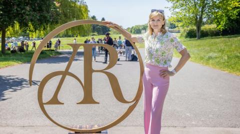 Fiona Bruce and an Antiques Roadshow sign