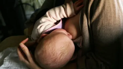 A news agency photo of a mother breastfeeding a newborn baby. 