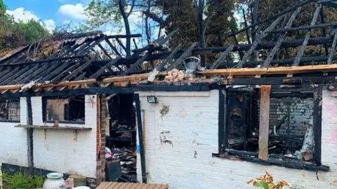 Contributed Another view of the pottery studio that was destroyed in a fire. Its wooden roof has been left broken and charred. The windows and door have been blown out. The contents inside the building have been burnt and destroyed.
