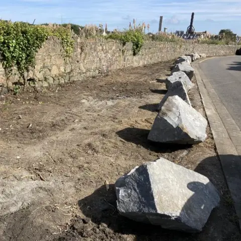 Boulders placed by side of a road