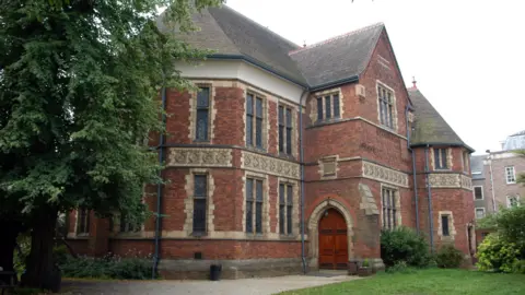 The exterior of the Oxford Union debating chamber, which is a large red brick building.