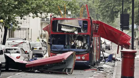 Dylan Martinez/Reuters/Pool/PA A photograph shows the scene of an explosion on a red double decker London bus on the day of the 7/7 terrorist attacks. Debris lies in the road and is strewn across the surrounding pavements and stationary traffic