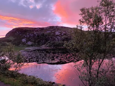 Lynn Martin A sunset with a pink sky over the fishing hamlet of Kylesku