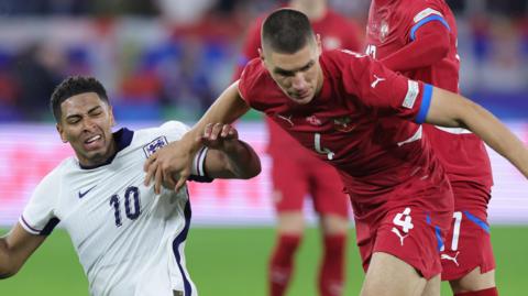 Nikola Milenkovic, wearing red, plays for Serbia against England