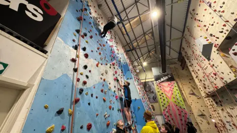 Two children climbing on a climbing wall 