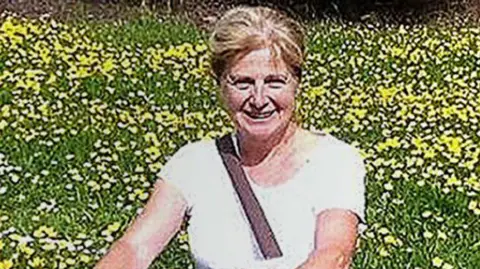 Wiltshire Police Danielle Carr-Gomm sat in a field of flowers
