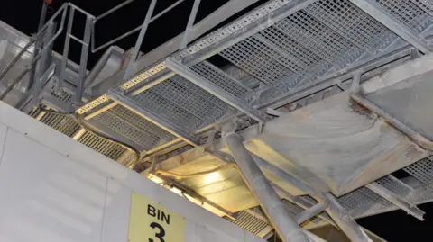 HSE A metal stairway showing a gap in between two steps