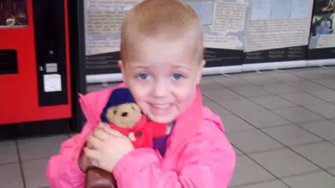 Chris and Jenny A young Rosie with her beloved Paddington bear