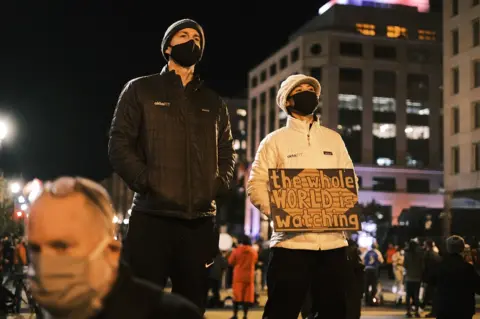 Getty Images A person holds a sign that reads "The Whole World Is Watching" at the Black Lives Matter Plaza on 3 November 2020 in Washington, DC