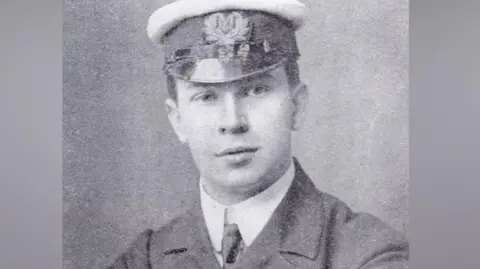 Jack Phillips, a telegraphist on board the Titanic. Jack is wearing a suit, tie and sailors hat in this black and white image.