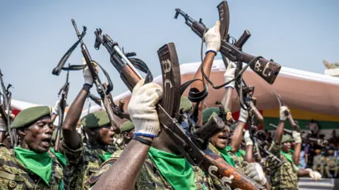 AFP Soldiers with the People's Revolutionary Armed Forces (FARP) hold their guns in the air during Guinea-Bissau's 50th Independence Day celebrations in Bissau on November 16, 2023. (