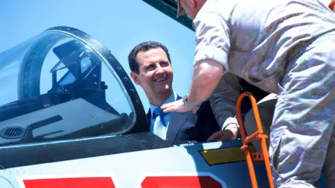 EPA Syrian President Bashar al-Assad (L) during his visit to Hmaymim Russian military airbase in Latakia province, Syria (27 June 2017)