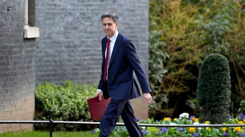PA Man in suit walking into Downing Street with red government folder
