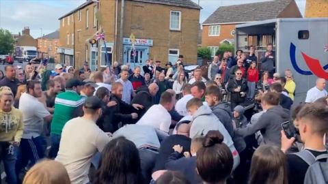 A "fight" involving several men watched by a crowd