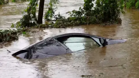 Black vehicle immersed in floodwater