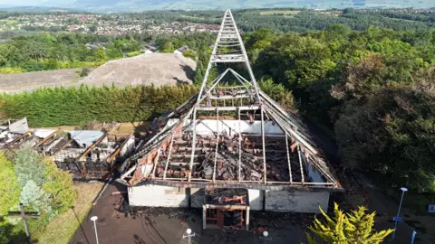 Graeme Ross A church destroyed by fire. The building, with a triangular roof, is in ruins.