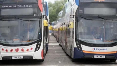 Two long queues of Stagecoach buses are facing the camera head on. 