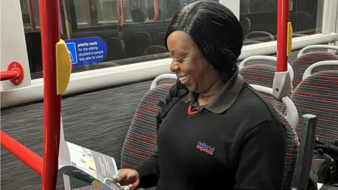 National Express West Midlands A female bus driver looking at a book