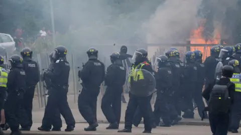 Danny Lawson/ PA Wire Police officers during an anti-immigration demonstration outside the Holiday Inn Express in Rotherham, South Yorkshire