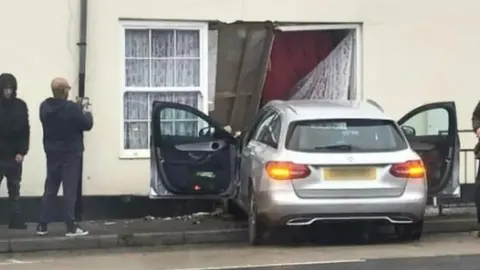 The car's front can be seen crashed into the property in a photo from the scene