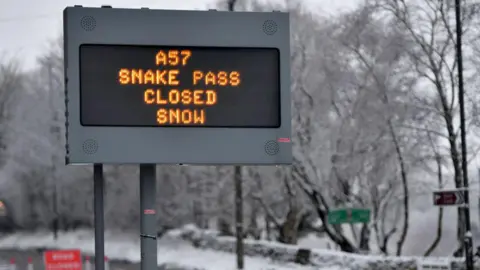 A sign saying the road is closed due to snow