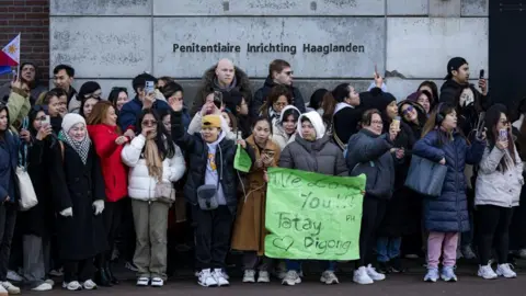 Getty Images A group of supporters of Duterte meets outside the detention center in Scheveningen, The Hague. One of them holds a green banner that reads, "We love you!"