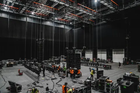 Production Park The inside of Studio 005, which has been transformed into a rehearsal space for a concert. Numerous speakers and lights have been suspended from the ceiling in the large hall.