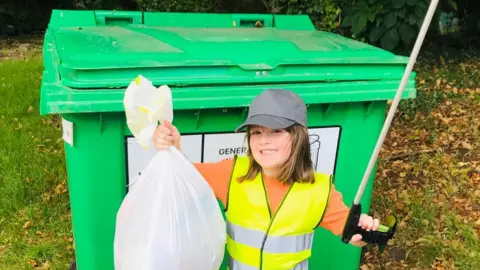 Matt Shannon Olivia Shannon with her litter-picker and bag of rubbish