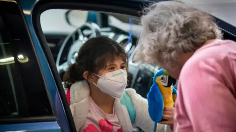 Getty Images Woman greets young relative at Thanksgiving
