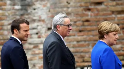 Getty Images Emmanuel Macron, Jean-Claude Juncker and Angela Merkel