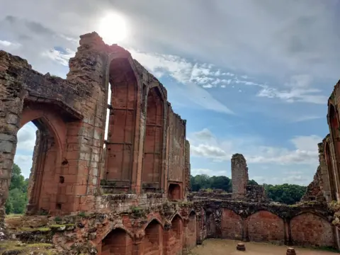 BBC Weather Watchers/Lynn Ruins of Kenilworth Castle under a blue sky with light white clouds and hazy sunshine.