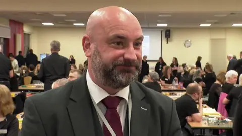 Lincolnshire Police and Crime Commissioner Marc Jones who has a beard and is wearing a dark jacket and purple tie