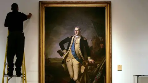 Getty Images A worker uses a ladder to work near a full length portrait of former U.S. President George Washington, by Charles Wilson Peale, at Christie's auction house January 17, 2006