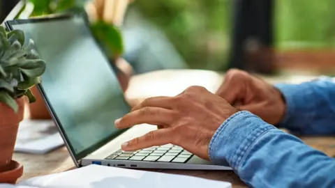 Getty Images someone typing at keyboard