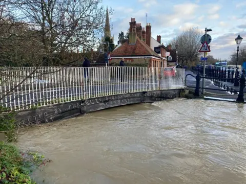 BBC A river almost high enough to flood a bridge