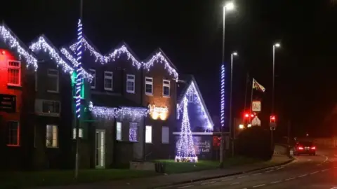 Caister Parish Council  A large property decorated with Christmas lights on the roof and several street lamps with twisted rope braid illuminations