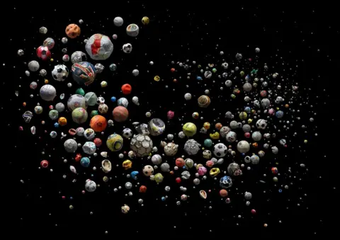 Mandy Barker Collection of marine debris footballs against a dark background