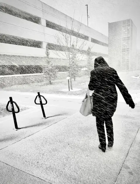 Leonardo Fugoso Jr A woman walks against snow being driven by wind in Wisconsin