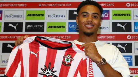 Lewis Dobbin holds up a Southampton shirt